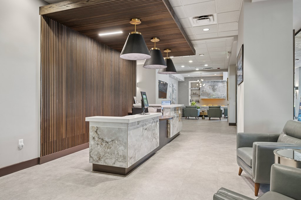 A reception area with a marble counter and a wooden wall.