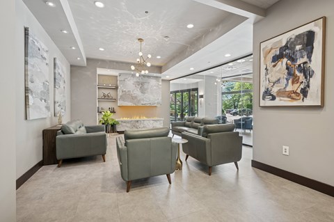 A living room with a grey couch and a painting on the wall.