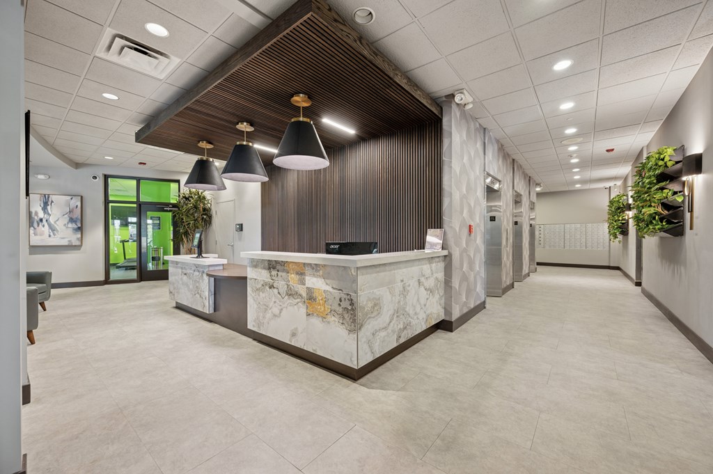 A reception area with a marble counter and a wooden ceiling.