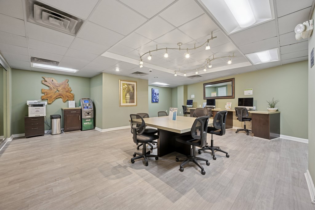 A conference room with a long table surrounded by chairs.