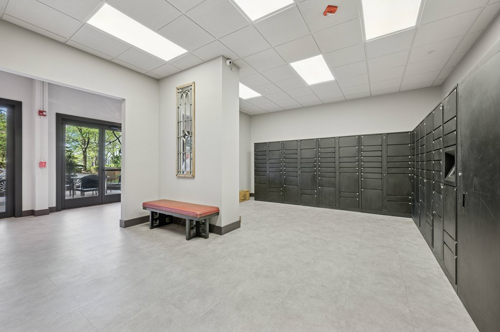 A room with a bench and a wall of lockers.