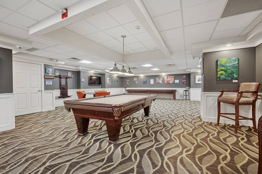 A room with a pool table and a chair.