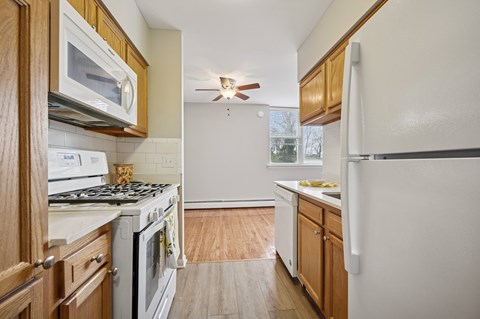 A kitchen with wooden cabinets and a white refrigerator.