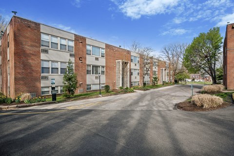 A street view of a residential area with brick apartment buildings on either side.