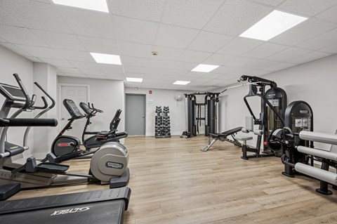 A gym with treadmills, elliptical machines, and other exercise equipment.
