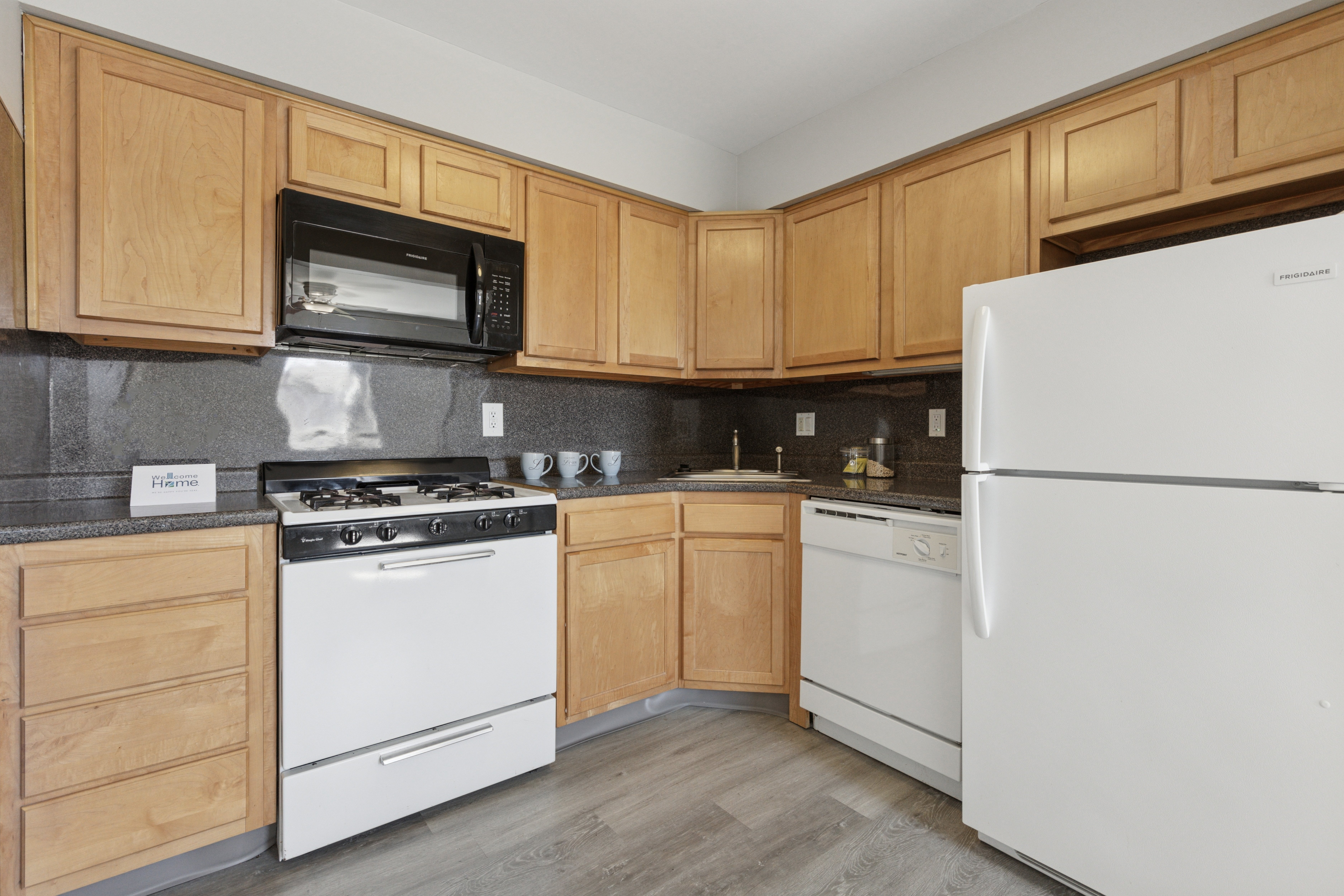 A kitchen with wooden cabinets and white appliances.
