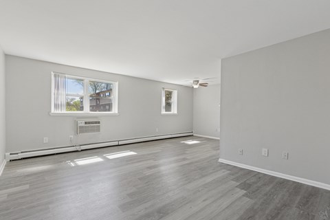 A room with a window and a wooden floor.