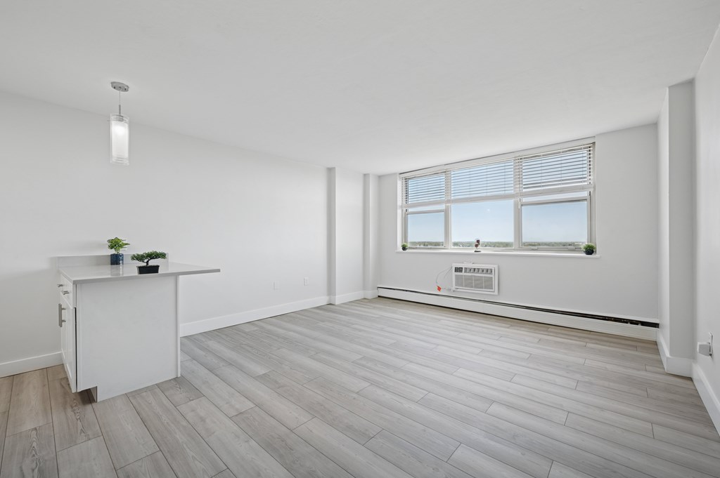 A room with a window and a desk with a plant on it.