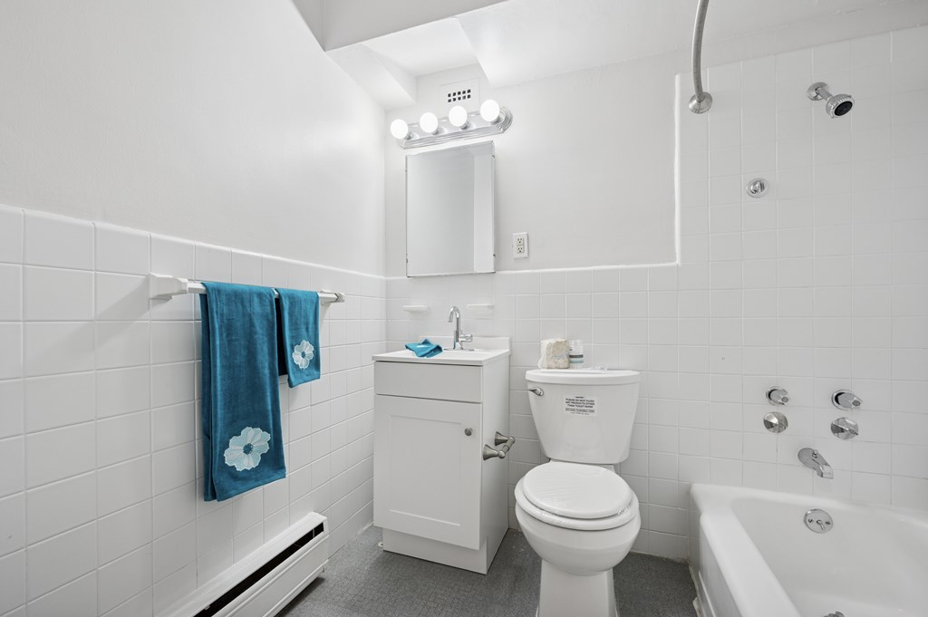 A white bathroom with a toilet, sink, and bathtub.