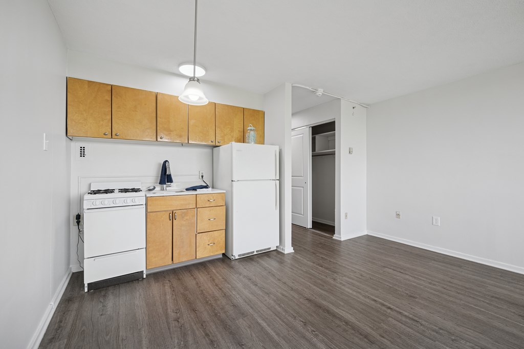 A kitchen with white appliances and wooden cabinets.