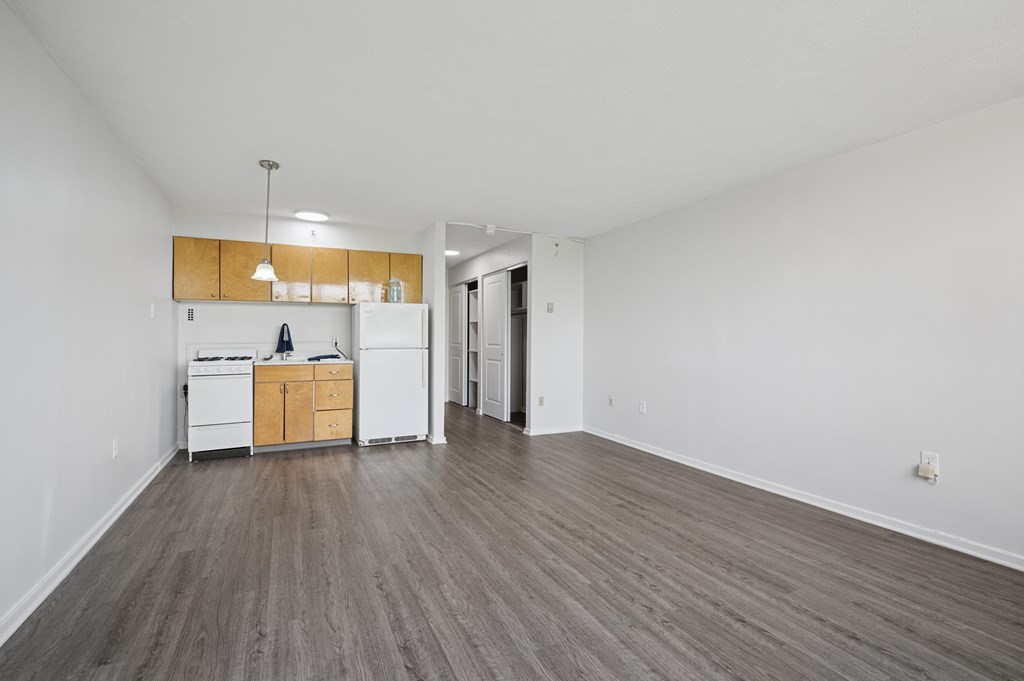 A kitchen with white appliances and wooden cabinets is in the image.
