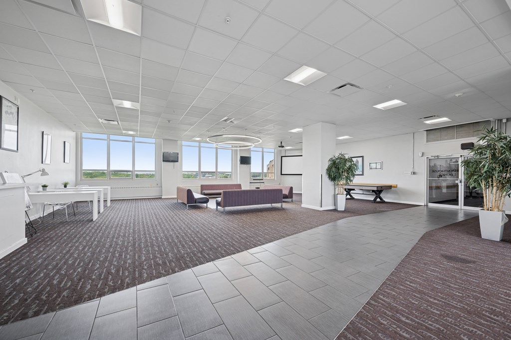 A spacious office with a carpeted floor and white walls.