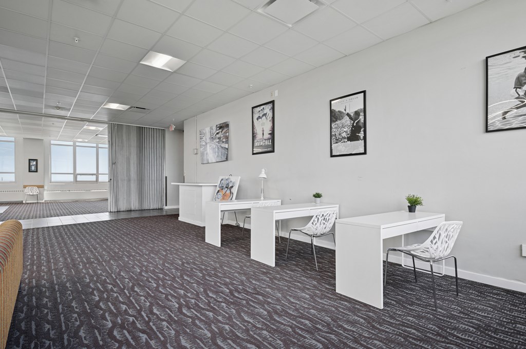 A room with a carpeted floor and white furniture.