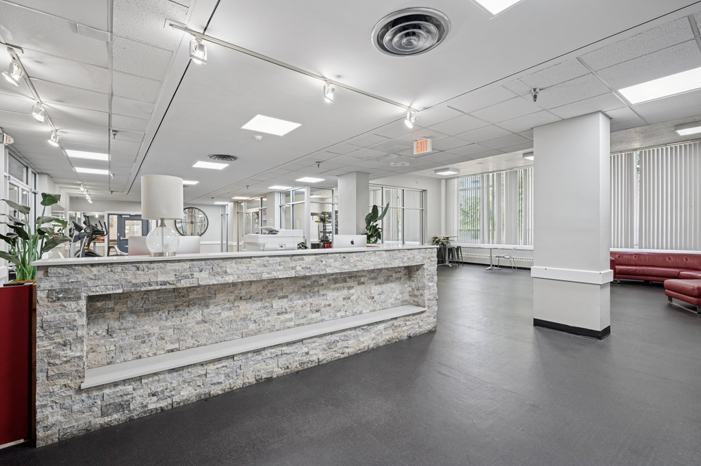 A reception area with a stone wall and a red couch.