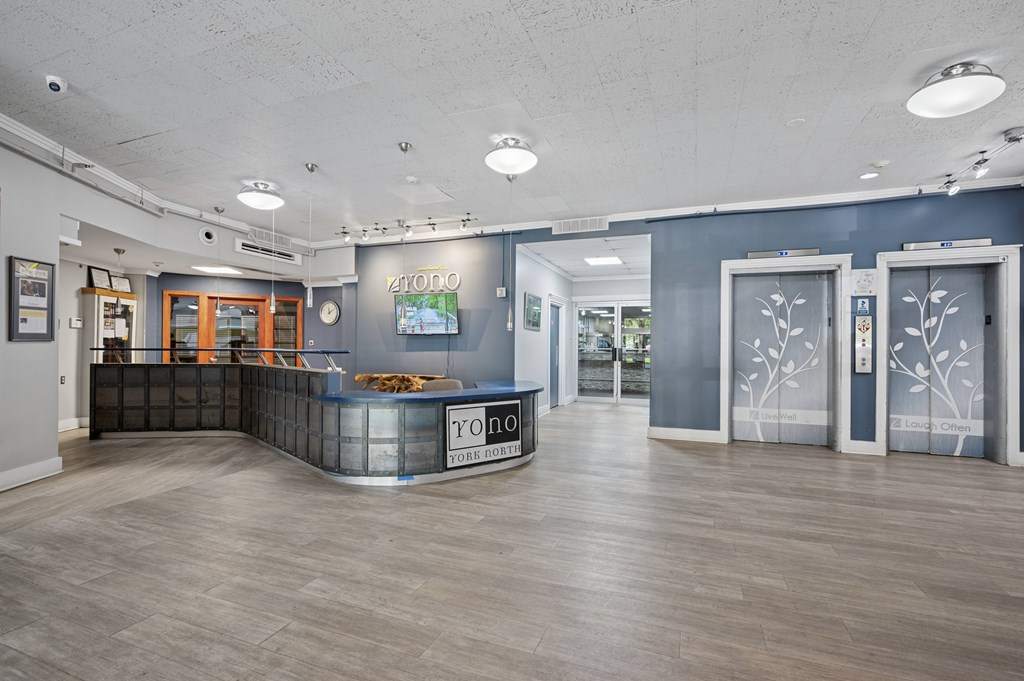 A reception area with a blue wall and a wooden floor.
