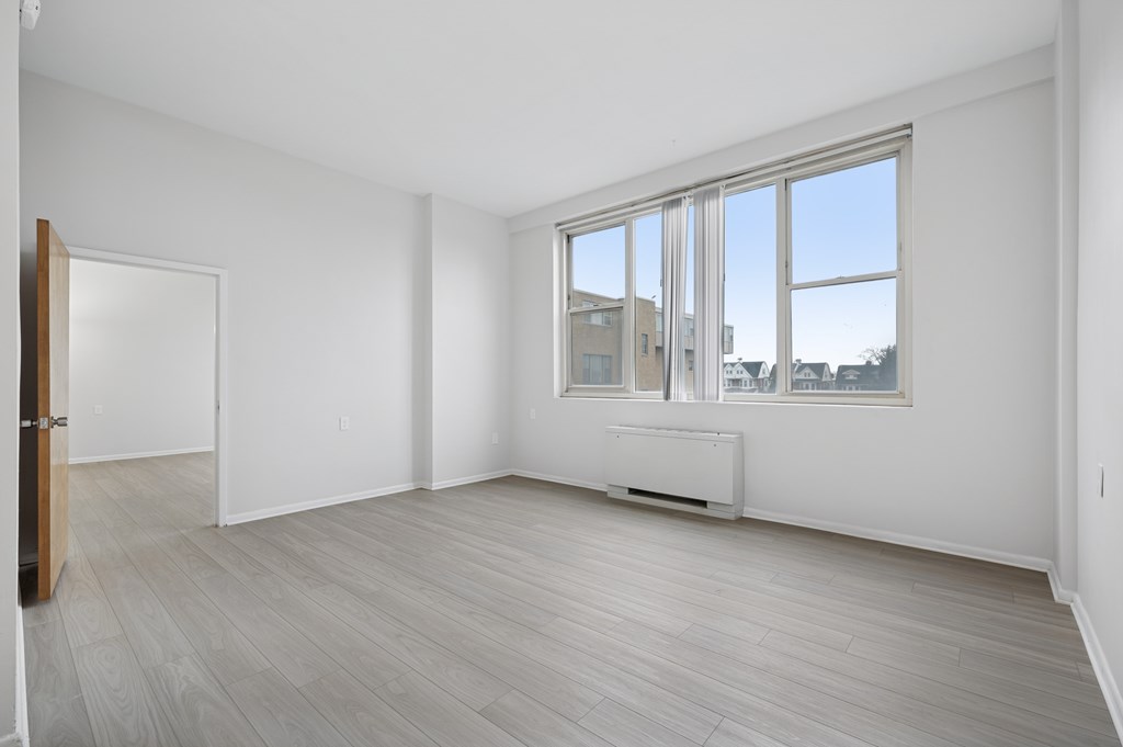 A room with a large window and a radiator on the floor.