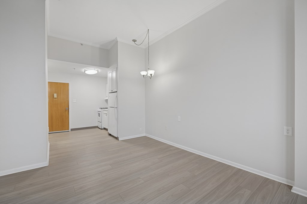 A kitchen with white appliances and a wooden door.