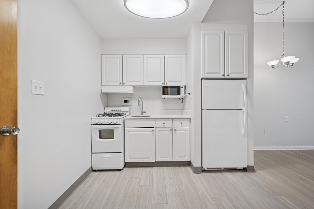 A kitchen with white appliances and cabinets.