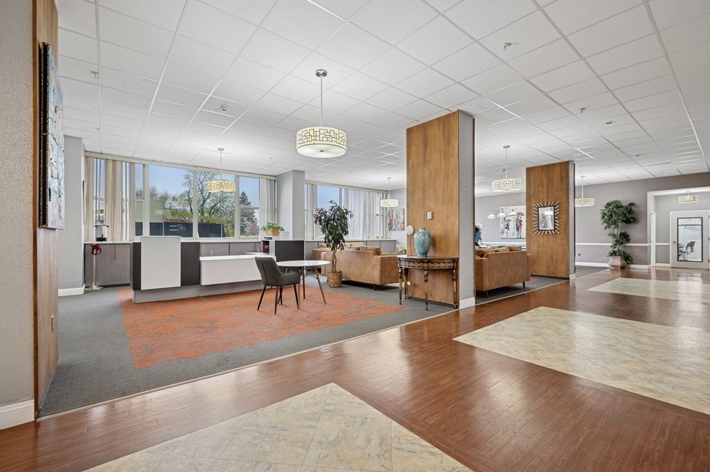 A spacious office lobby with a reception desk and a large window overlooking the outdoors.