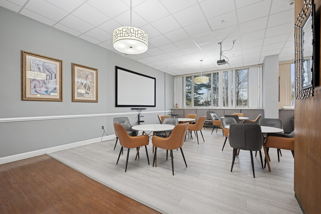 A conference room with a long table and chairs.