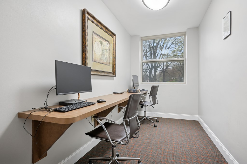 A room with a desk and chairs.
