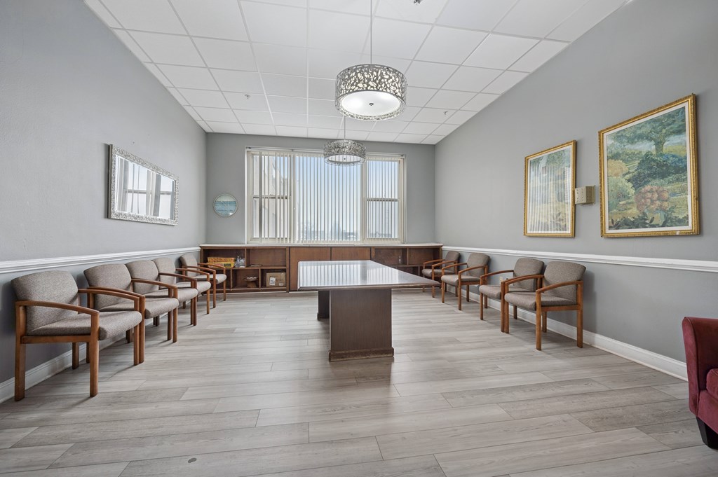 A conference room with a long table and chairs.