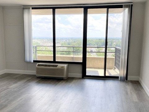 an empty living room with sliding glass doors and a balcony