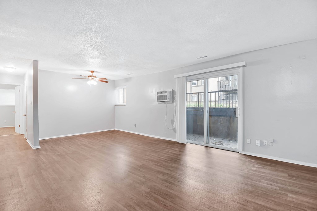 Large room with hardwood floors and sliding glass door