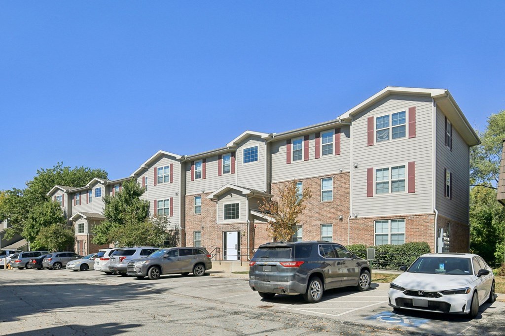 A row of cars parked in front of a building.