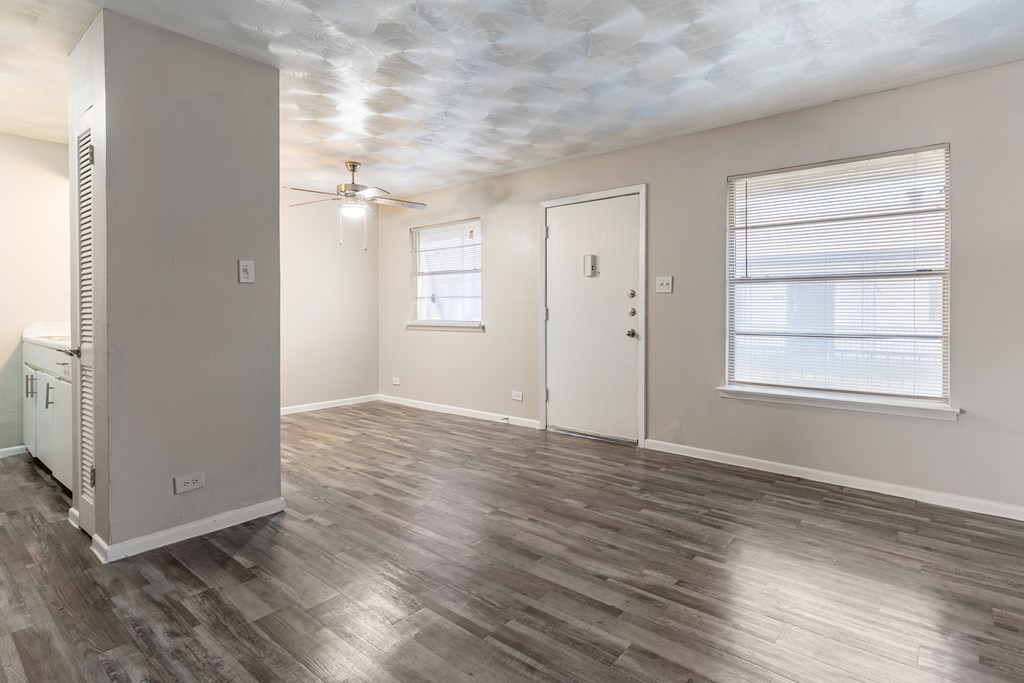 A room with a wood floor and a ceiling fan.