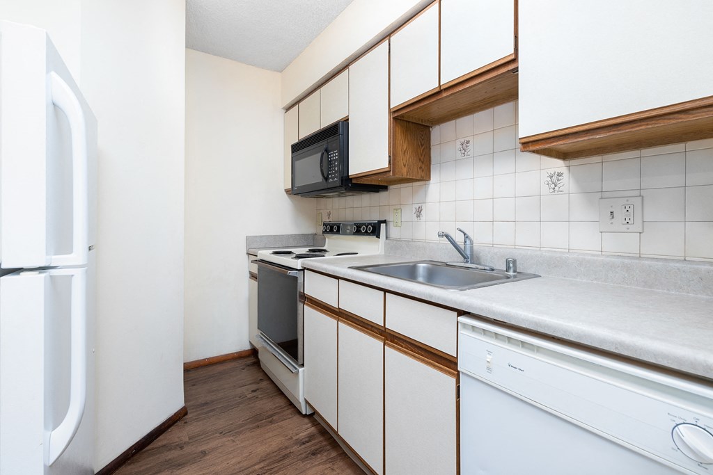 a kitchen with white cabinets and a sink and a refrigerator