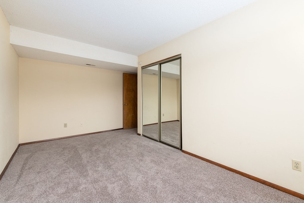 a room with carpet and a mirror on the wall