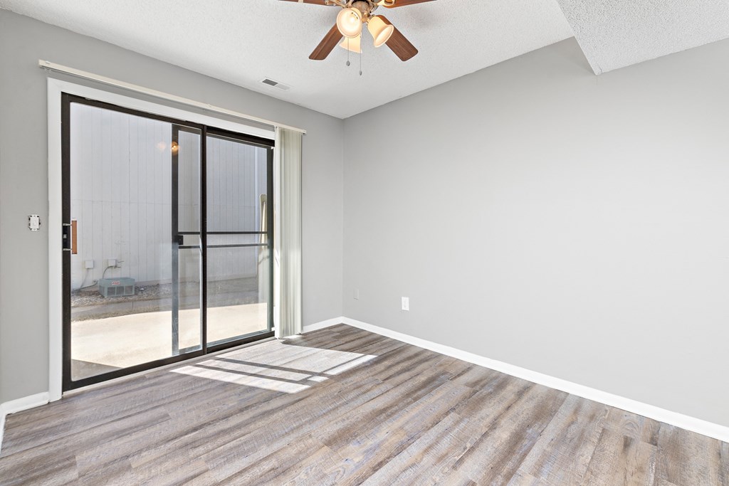 Living room with large patio door at Eddingham in Lawrence, KS