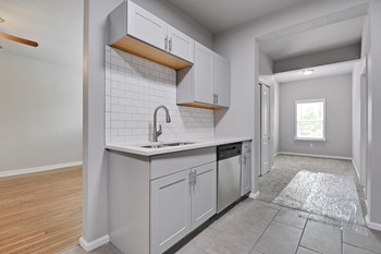 Image of kitchen with stainless steel appliances, new cabinets, and exposed brick - Photo Gallery 5