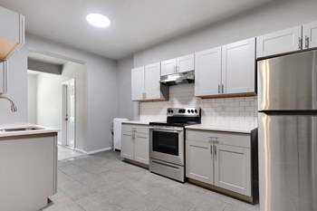 Image of kitchen with stainless steel appliances, new cabinets, and exposed brick - Photo Gallery 4