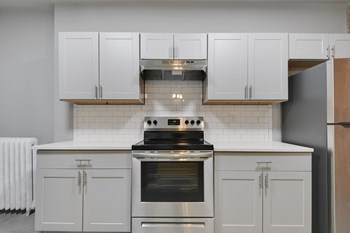 Image of kitchen with stainless steel appliances, new cabinets, and exposed brick - Photo Gallery 6