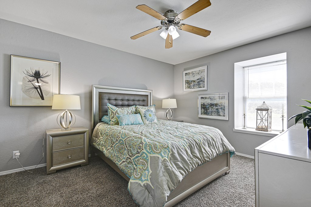 carpeted bedroom with ceiling fan and huge window