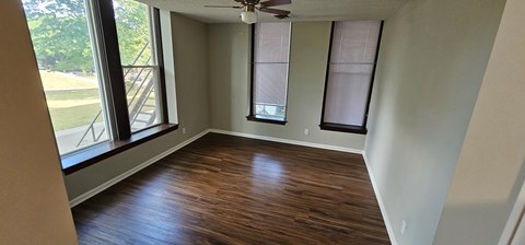 A room with wooden floors and a ceiling fan.