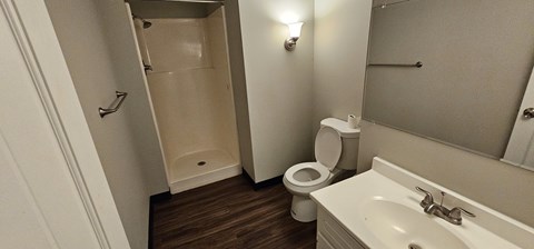 A white toilet sits in a small bathroom next to a sink.