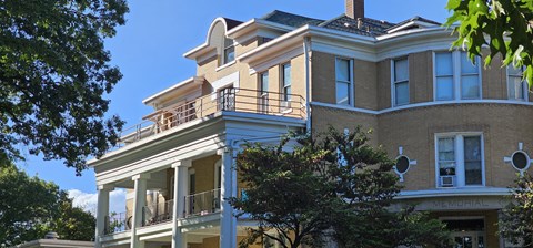 A large, two-story building with a balcony on the upper floor.
