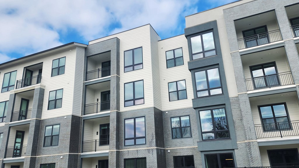 a large apartment building with many windows and a blue sky