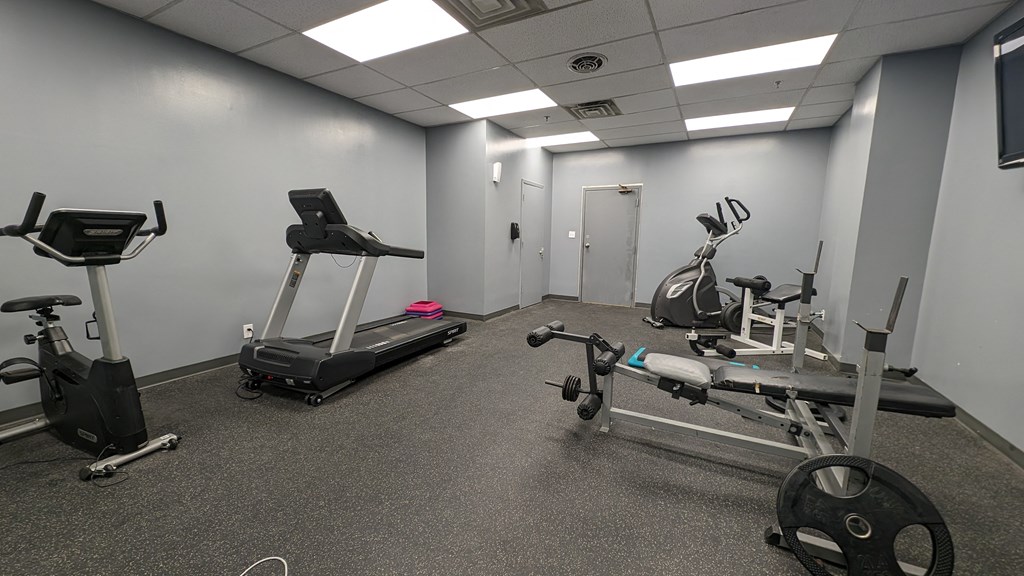 a gym with exercise equipment and weights in a building