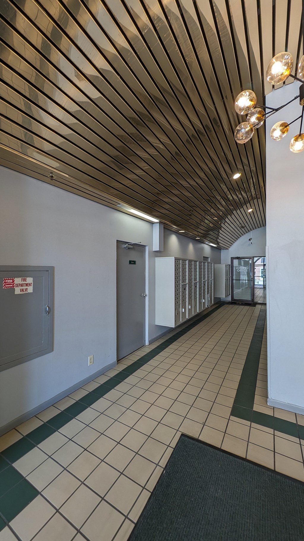 a hallway with white walls and a wood ceiling with lights and doors