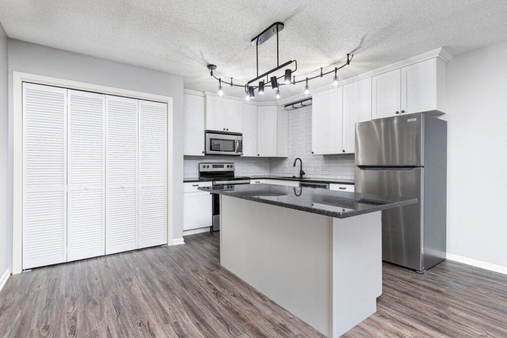 Photo of kitchen with white cabinetry and stainless steel appliances in Fairway, Kansas.