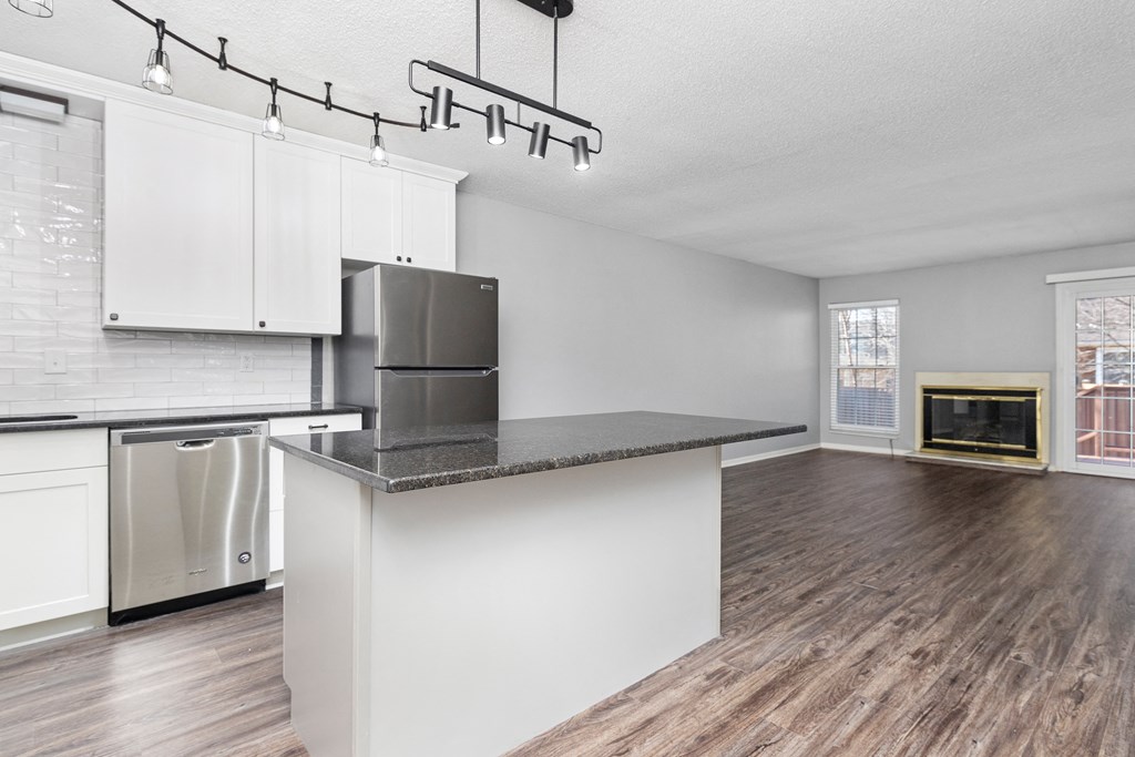 Photo of kitchen with white cabinetry and stainless steel appliances with view of hallway in Fairway, Kansas.