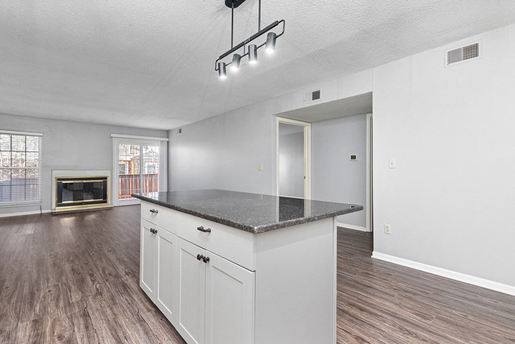 Photo of kitchen with white cabinetry and stainless steel appliances with view of hallway in Fairway, Kansas.