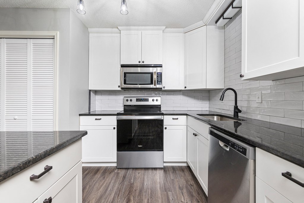 Photo of kitchen with white cabinetry and stainless steel appliances in Fairway, Kansas.