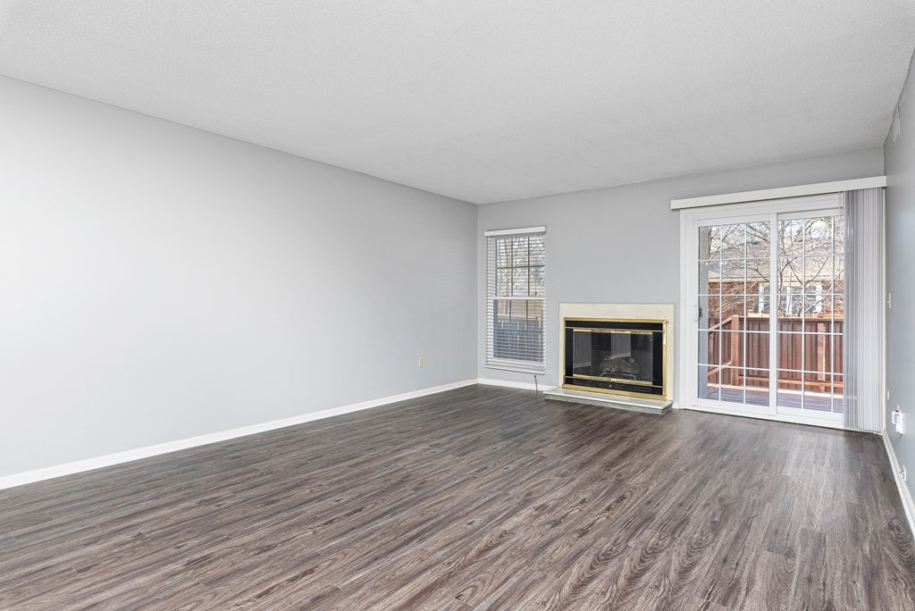 Photo of living area with vinyl flooring and fireplace with view of patio door in Fairway, Kansas.