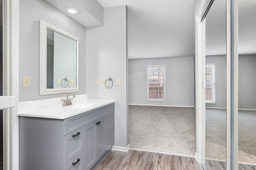 Photo of bathroom with vinyl flooring with white countertop and view in to carpeted bedroom in Fairway, Kansas.