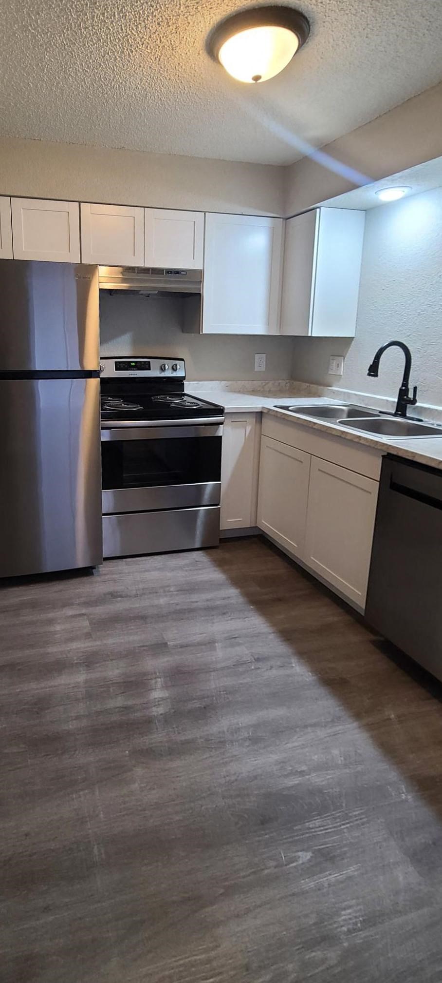 a kitchen with stainless steel appliances and white cabinets
